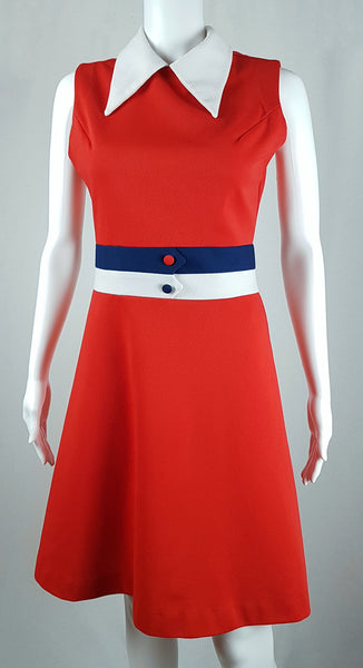Full front view of a vintage 1970s Kenny Classics Donnkenny orange-red mod dress with a white pointed collar, navy and white waist bands and contrasting covered buttons displayed on a mannequin