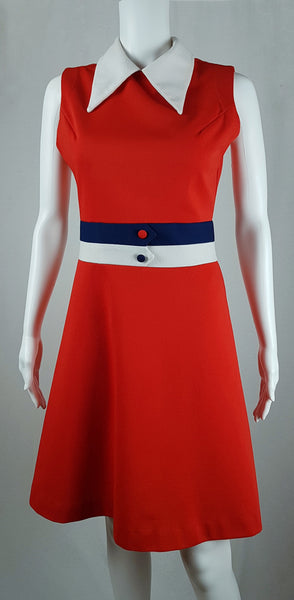 Full front view of a vintage 1970s Kenny Classics Donnkenny orange-red mod dress with a white pointed collar, navy and white waist bands and contrasting covered buttons displayed on a mannequin