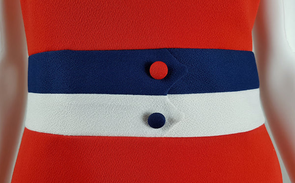 Close-up of the navy and white waist bands with contrasting covered buttons on a vintage 1970s Kenny Classics orange-red dress.