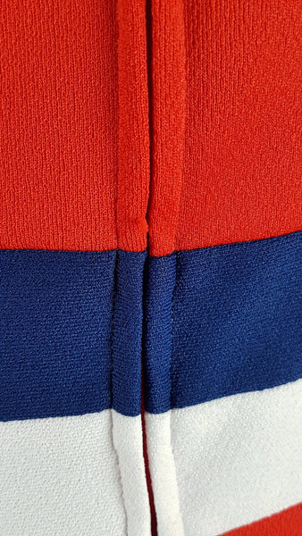 Close up back view of a back zipper on a vintage 1970s Kenny Classics Donnkenny orange-red mod dress with contrasting navy and white waist bands 