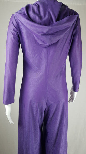 Back hood view of a 1970s Nu-Mode purple jumpsuit with a draped hood, V-neckline, front zip and ties, long sleeves and wide legs displayed on a mannequin 