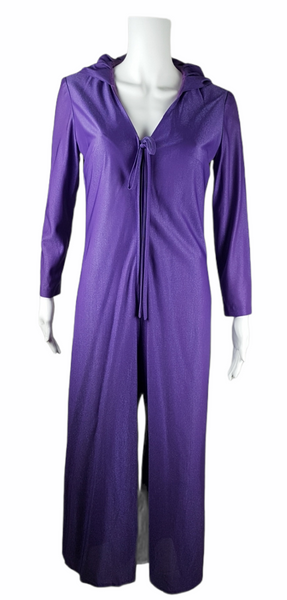 Front view of a 1970s Nu-Mode purple jumpsuit with a draped hood, V-neckline, front zip and ties, long sleeves and wide legs displayed on a mannequin 