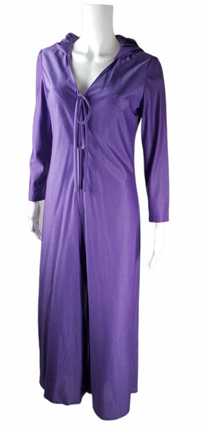 three quarter view of a 1970s Nu-Mode purple jumpsuit with a draped hood, V-neckline, front zip and ties, long sleeves and wide legs displayed on a mannequin 