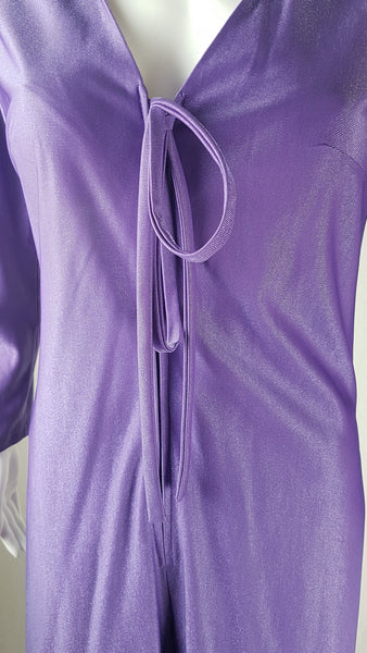 Front zipper and torso view of a 1970s Nu-Mode purple jumpsuit with a draped hood, V-neckline, front zip and ties, long sleeves and wide legs displayed on a mannequin 