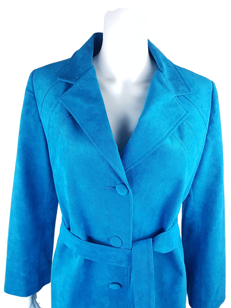 Upper front view showing the turquoise coat’s notched lapels, curved seams and fabric-covered buttons