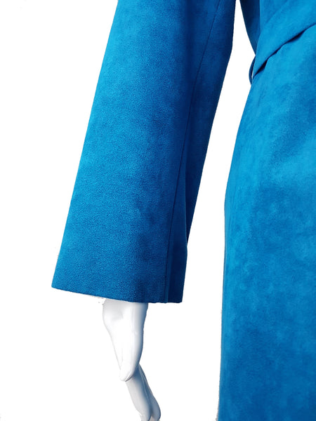Close-up of the long sleeves and straight cuffs in vivid turquoise faux suede