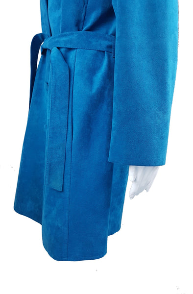 Side view showing the coat’s knee-length silhouette, inset pocket and matching belt