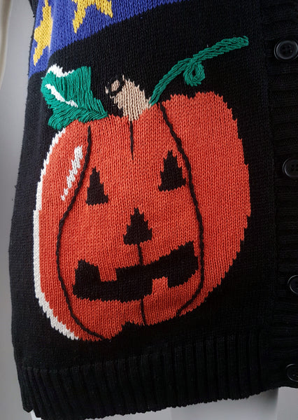 Close-up of the orange jack-o’-lantern with green stem and embroidered facial details