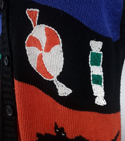 Close-up of knitted wrapped sweets and striped candy beside the black button placket