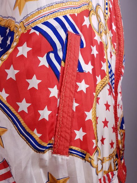 Close-up of the red-trimmed pocket and bold USA flag, star and gold-chain print on a vintage 1980s - 1990s Mureli silk bomber jacket.