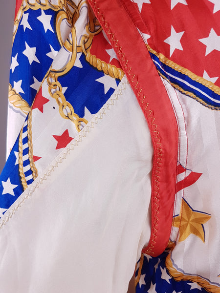 Close-up of the red-trimmed detachable sleeves and bold USA flag, star and gold-chain print on a vintage 1980s - 1990s Mureli silk bomber jacket.