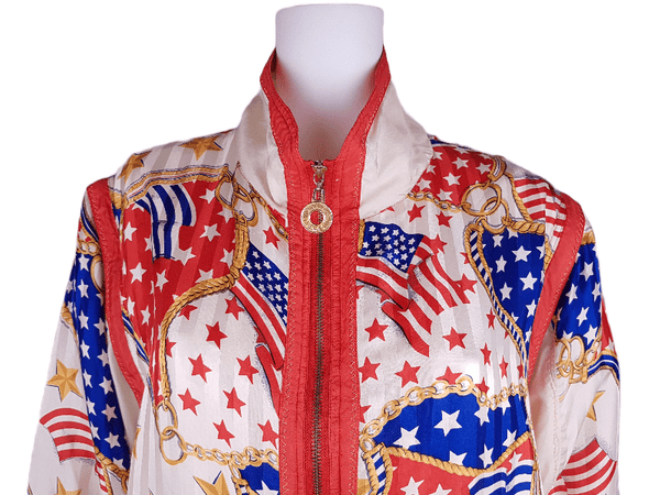 Closeup front shoulder and collar view of a Vintage 1980s - 1990s  Mureli silk bomber jacket with a red, white, blue and gold USA flag and chain print, detachable sleeves, red trim and an oversized blouson silhouette, displayed on a mannequin