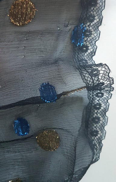 Condition photograph identifying tiny pinholes near the lace-trimmed hem of the Vintage 1980s Edith Strauss Black Silk Metallic Polka-Dot Midi Dress