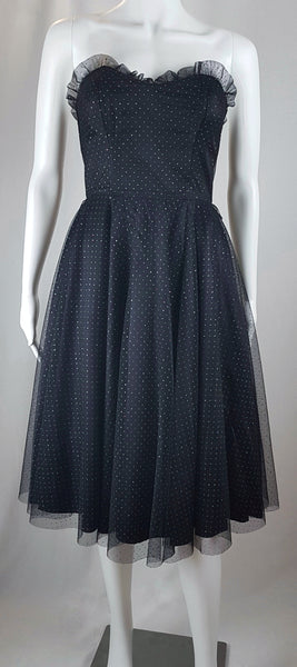 Full front view of a vintage 1980's Gunne Sax black formal dress with multicolor glitter dots, a pleated tulle sweetheart neckline and fitted bodice and full sweep skirt with a built-in crinoline displayed on a mannequin