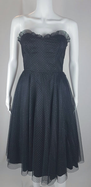 Full front view of a vintage 1980's Gunne Sax black formal dress with multicolor glitter dots, a pleated tulle sweetheart neckline and fitted bodice and full sweep skirt with a built-in crinoline displayed on a mannequin