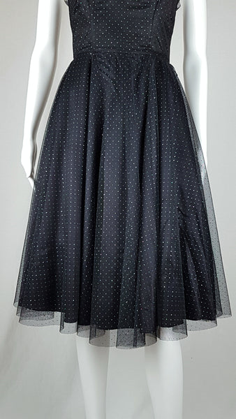 Full hemline and skirt view of a vintage 1980's Gunne Sax black formal dress with multicolor glitter dots, a pleated tulle sweetheart neckline and fitted bodice and full sweep skirt with a built-in crinoline displayed on a mannequin