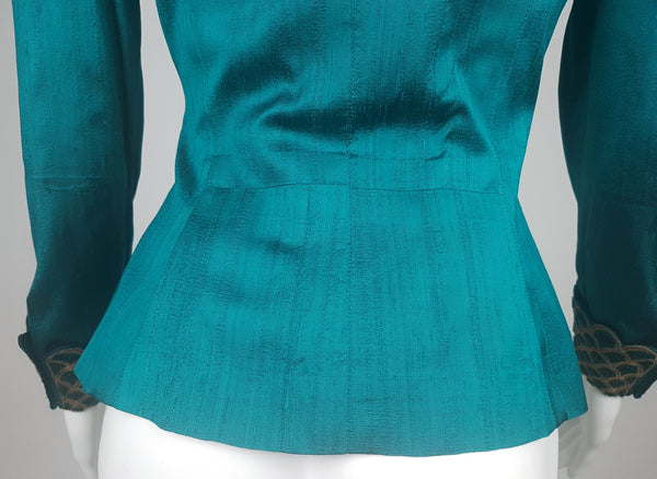 Lower back view of a vintage teal silk jacket showing the shaped waist seams and gently flared peplum-style hem.