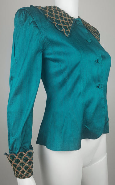 Three-quarter front mannequin view of a vintage 1980s Spaghetti London teal silk evening jacket with a beaded statement collar and deep embellished cuffs.