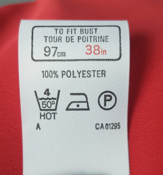 Care and sizing label view of buttons on a vintage 1980s St Michael red pussy-bow blouse with stitched front pleats, fabric-covered buttons and gathered long sleeves 
