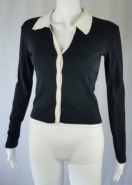  Full front view of the vintage 1990s Agnès b. fitted black cotton cardigan top with long sleeves and a contrasting white collar displayed on a mannequin