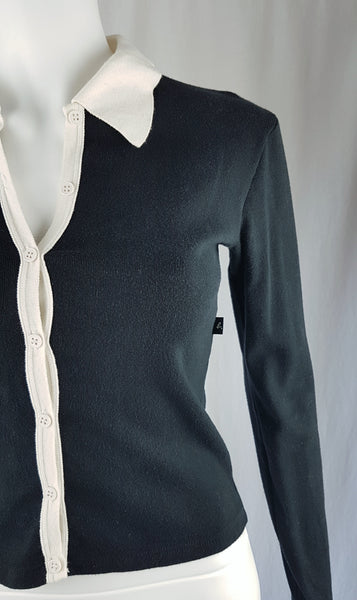  Close up front view of the vintage 1990s Agnès b. fitted black cotton cardigan top with long sleeves and a contrasting white collar displayed on a mannequin