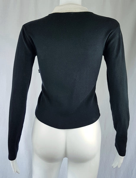 Full back view of a vintage 1990s Agnès b. fitted black cotton cardigan top with long sleeves and a contrasting white collar displayed on a mannequin