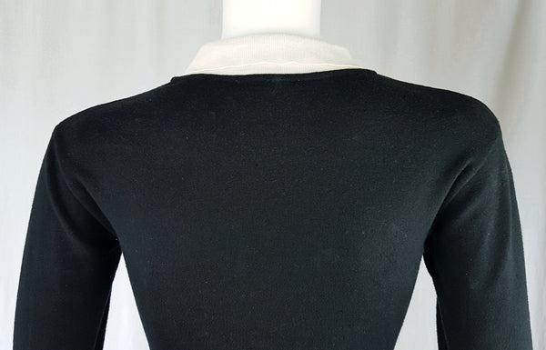 Closeup back view of a vintage 1990s Agnès b. fitted black cotton cardigan top with long sleeves and a contrasting white collar displayed on a mannequin