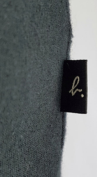 Close-up of the Agnès b. Paris tag on a vintage 1990s black-and-white cotton cardigan top