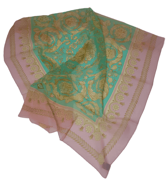 Flatlay gathered view of a vintage early 1990s Atelier Versace square silk scarf in pastel pink and aqua with ornate gold floral scrollwork.