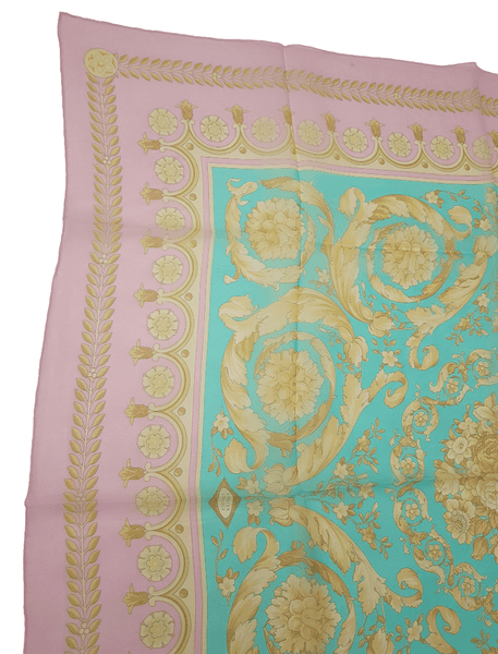 Fabric closeup of Vintage Atelier Versace silk scarf, showing its aqua centre, pink border and ornate floral design.