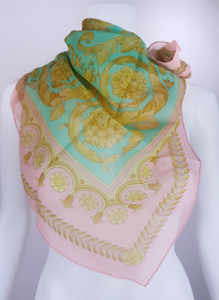 Vintage 1990s Atelier Versace silk scarf styled around a dress form, showing its aqua centre, pink border and ornate floral design.