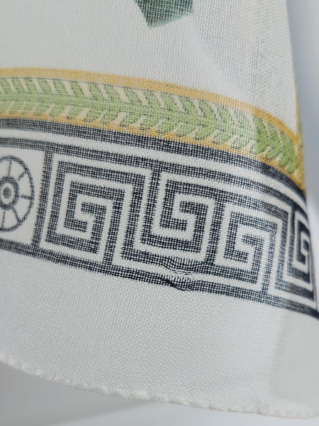 Close-up of the black Greek-key border and green-and-gold botanical band on a vintage 1990s Gianni Versace Profumi ivory chiffon scarf.