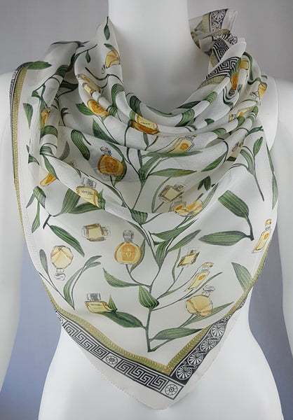 Vintage 1990s Gianni Versace Profumi ivory chiffon scarf draped in a triangle, showing its perfume-bottle print and Greek-key border.