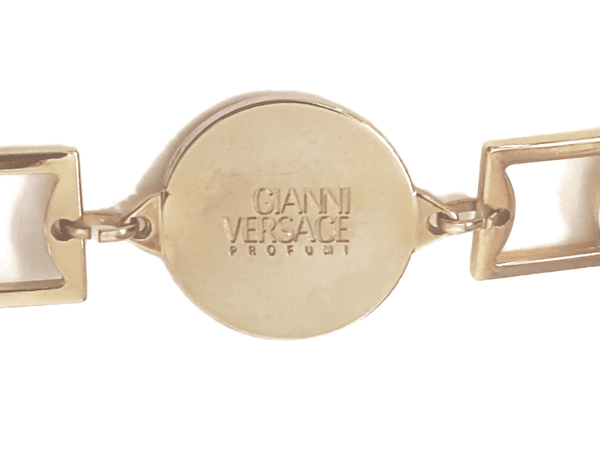 Back of a circular medallion stamped GIANNI VERSACE PROFUMI between two open square links