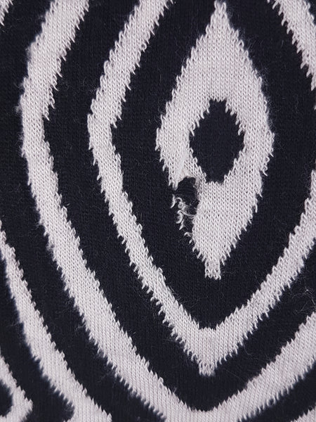 Close up of one small damaged area on the left rear shoulder on  vintage 1990s Le Château black-and-white patterned jacket.The disruption is not immediately noticeable within the bold pattern but should be considered before purchase.