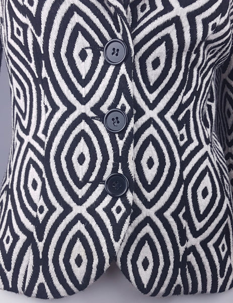 Close-up of the black button fastening on a vintage 1990s Le Château black-and-white patterned jacket.