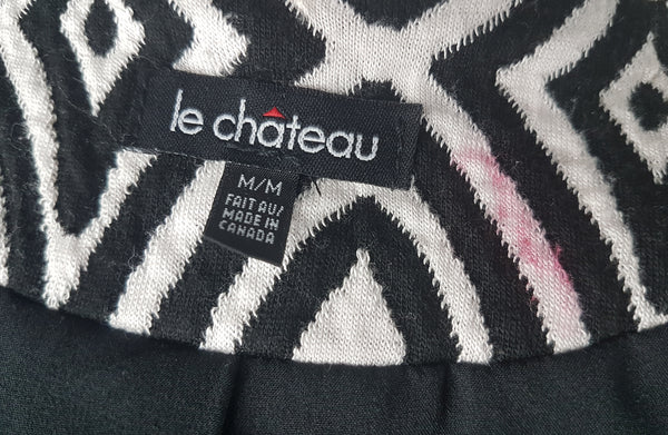 Close-up of the Le Château label and size tag inside a vintage 1990s black-and-white op-art jacket, showing it was made in Canada, also shows faint red stain on inside of collar (not visible when worn)
