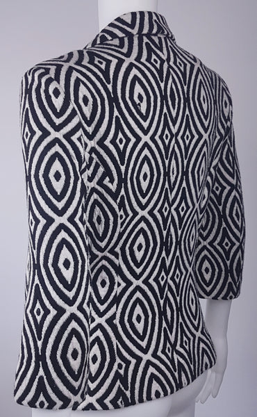 Full back three quarter view of a vintage 1990s Le Château black-and-white op-art jacket with notched lapels and a three-button closure displayed on a mannequin