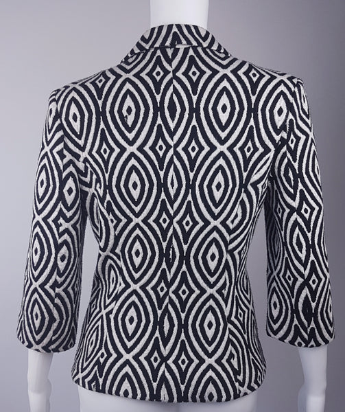 Full back view of a vintage 1990s Le Château black-and-white op-art jacket with notched lapels and a three-button closure displayed on a mannequin
