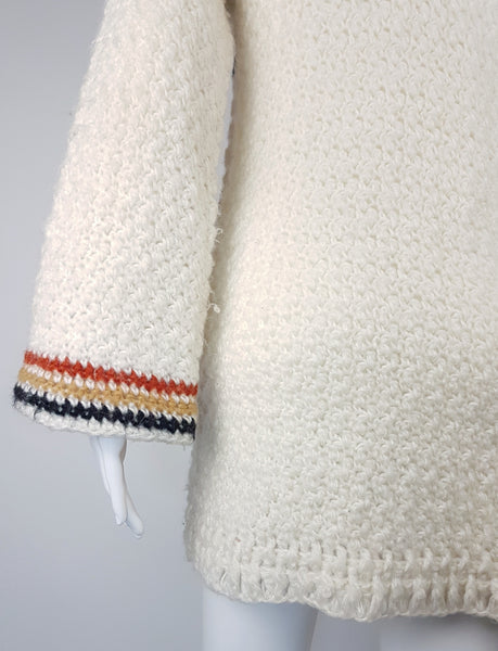 Sleeve of a Leroy Knitwear cream cardigan sweater with deer motifs and wooden buttons, displayed on a mannequin.