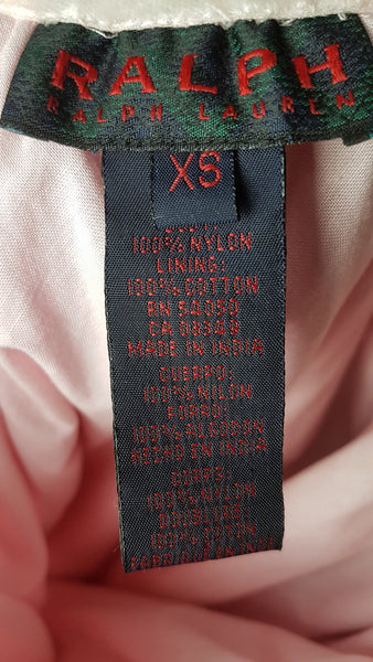 Close-up of the RALPH Ralph Lauren label and fibre-content tag inside a vintage pink tulle skirt, showing size XS and Made in India.