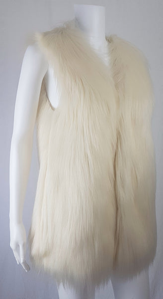 Full three quarter view of a cream long-pile faux-fur vest with a collarless neckline, decorative fastening and side pockets displayed on a mannequin