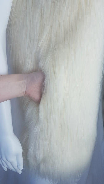 Close-up of a concealed side-seam pocket in a cream long-pile faux-fur vest.