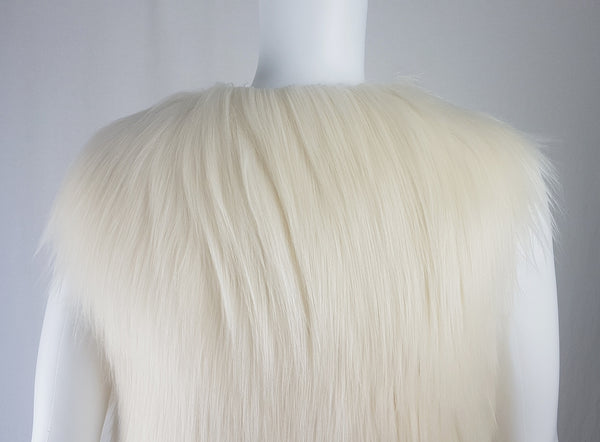 Close up back view of a cream long-pile faux-fur vest with a collarless neckline displayed on a mannequin