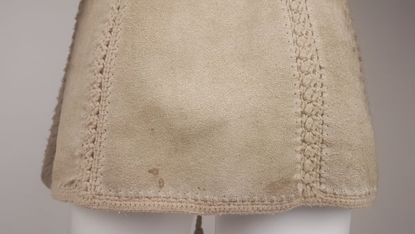 Lower back view of the suede vest, showing its patina and a faint stain near the hem