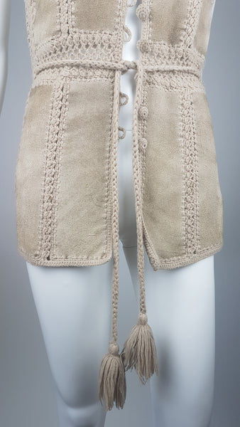 Lower front view of a vintage 60s - 70s Hudson Bay Company  suede vest showing the fitted waist, long front panels and braided tassel belt.