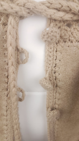 Detailed view of the crochet-covered buttons and loop fastenings along the front of the vintage suede vest.
