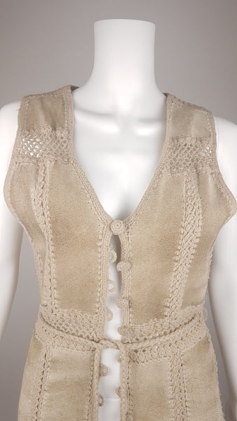 Upper front view of a vintage 60s - 70s Hudson Bay Company sand-beige suede vest with a deep V-neck, wide shoulders and crochet-covered loop buttons.