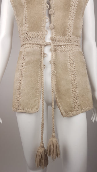 Lower front view of a vintage 60s - 70s Hudson Bay Company  suede vest showing the fitted waist, long front panels and braided tassel belt.