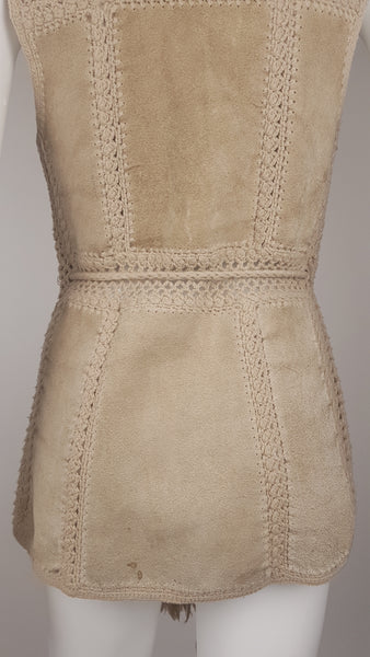 Lower back view of a vintage 60s - 70s Hudson Bay Company panelled beige suede vest with a wide crochet waistband and visible natural patina displayed on a mannequin